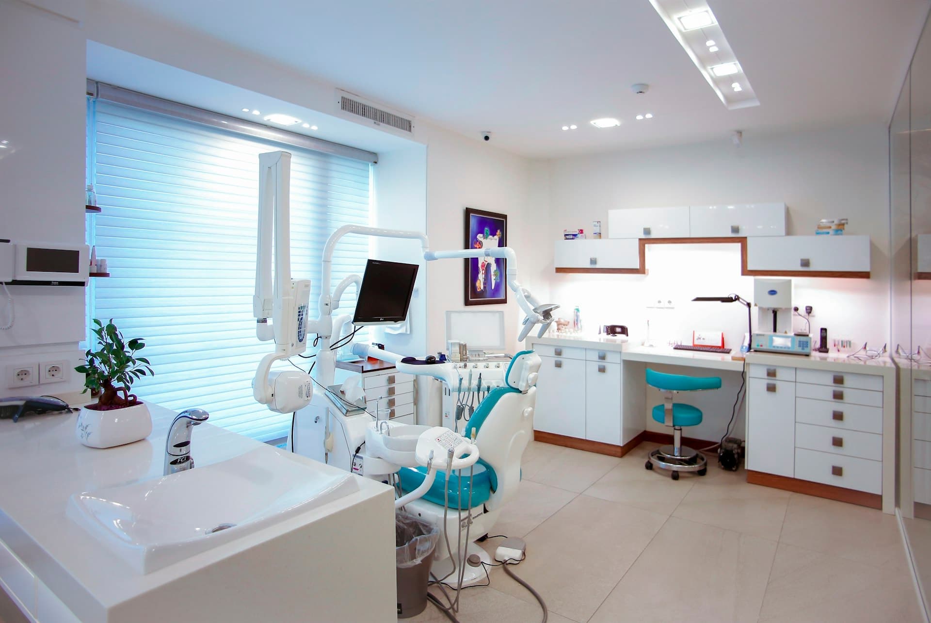 Consultório odontológico com cadeira, refletor e bancada de instrumentos