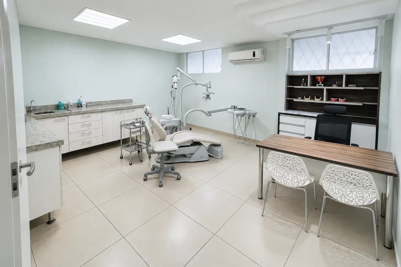 Consultório da Prodentex visto da porta, com cadeira odontológica, bancada e mesa de atendimento