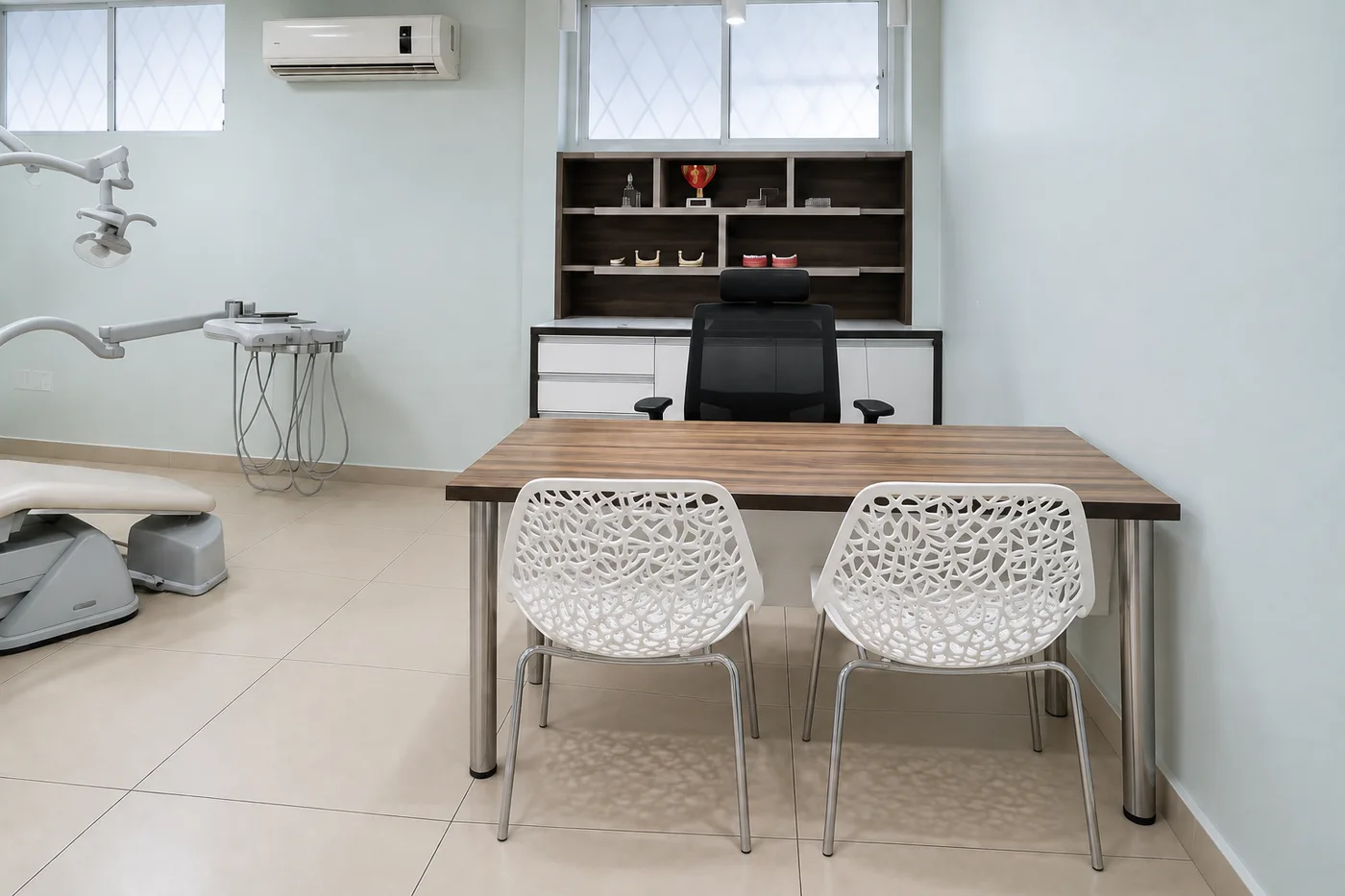 Mesa de atendimento da Prodentex, com duas cadeiras e estante com modelos de gesso